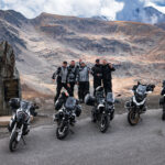 Grupo de motoristas ante un impresionante telón de fondo alpino con varias motos BMW y KTM, ideal para excursiones en moto por la montaña.