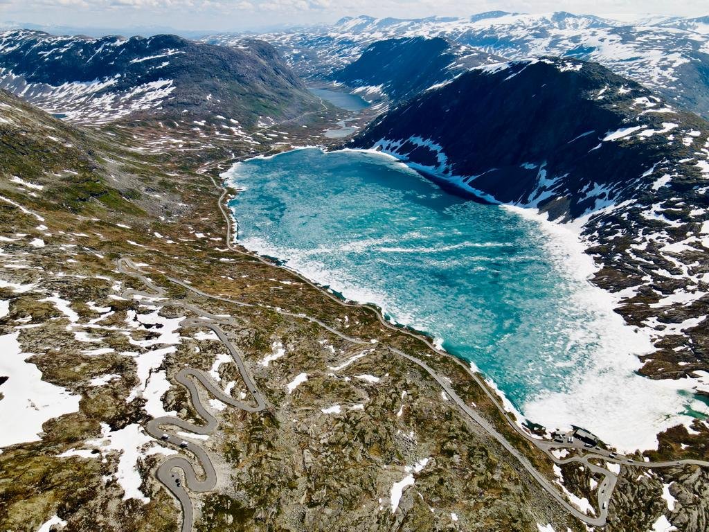 Snow-covered road along a glacial lake in Norway - a dream route for motorcyclists.